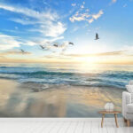 Wall murals Beach with birds flying over the water