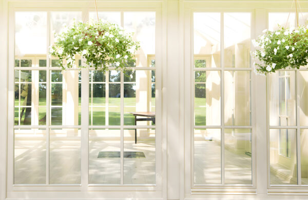 White patio door with glass windows and a potted plant from it White patio door with glass windows and a potted plant from it