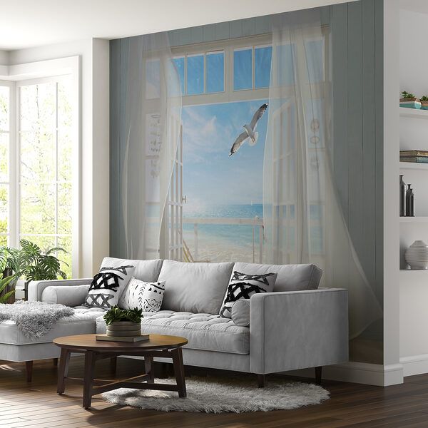 View of a beach from a room with a bird flying over it View of a beach from a room with a bird flying over it